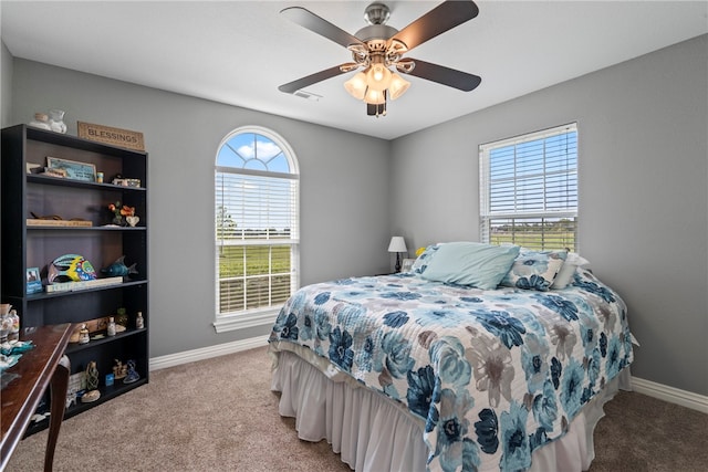 carpeted bedroom featuring multiple windows and ceiling fan