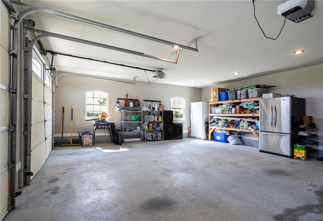 garage featuring stainless steel fridge and a garage door opener