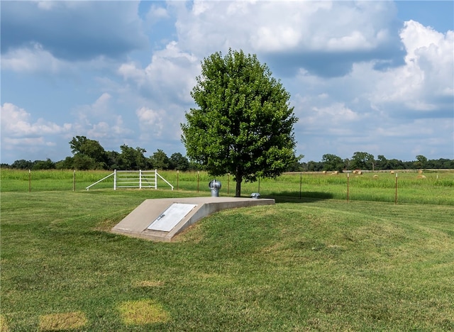 view of storm shelter with a rural view and a yard