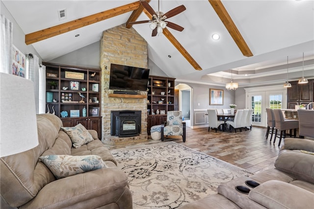 living room with a fireplace, built in shelves, ceiling fan with notable chandelier, high vaulted ceiling, and beamed ceiling