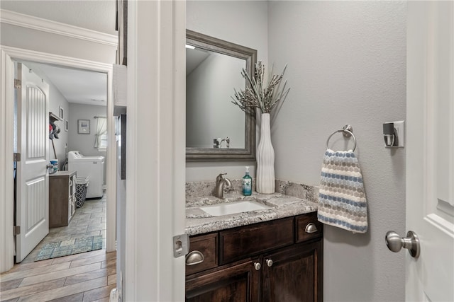 bathroom with separate washer and dryer, vanity, crown molding, and toilet