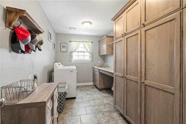 laundry room with light tile patterned floors, washer and clothes dryer, sink, and cabinets