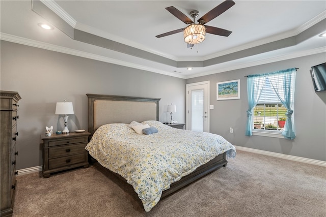 carpeted bedroom with a raised ceiling, ornamental molding, and ceiling fan