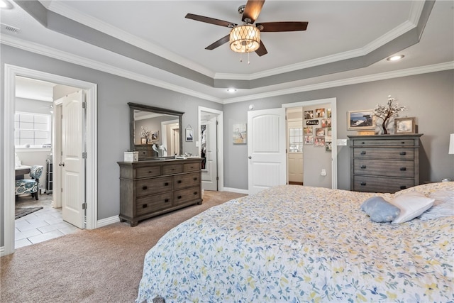 carpeted bedroom featuring ensuite bath, ceiling fan, crown molding, and a tray ceiling