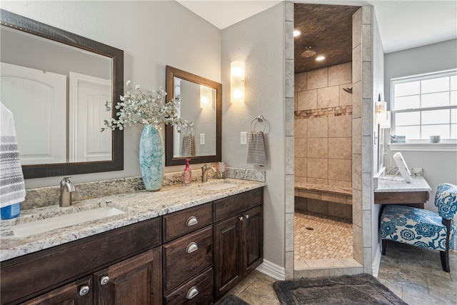 bathroom featuring tiled shower, tile patterned flooring, and double vanity