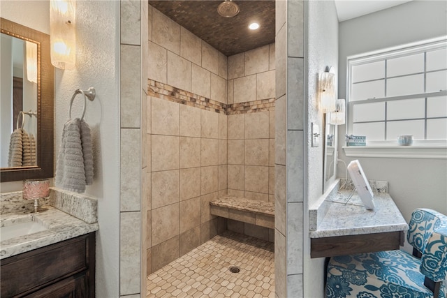 bathroom featuring tiled shower and vanity