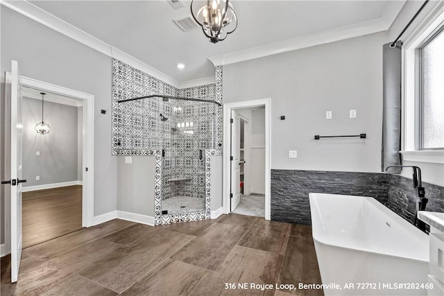 bathroom with ornamental molding, shower with separate bathtub, and an inviting chandelier