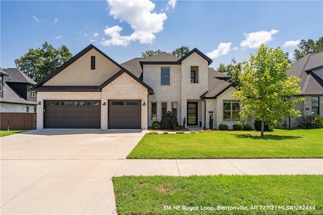 french country style house with a garage and a front lawn