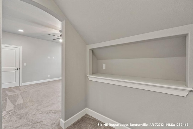 hallway featuring carpet floors and vaulted ceiling