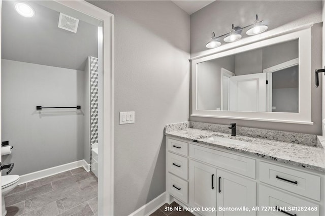 full bathroom featuring washtub / shower combination, vanity, and toilet