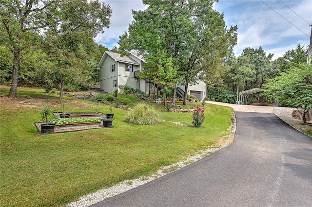 exterior space featuring a garage, a front lawn, and a carport