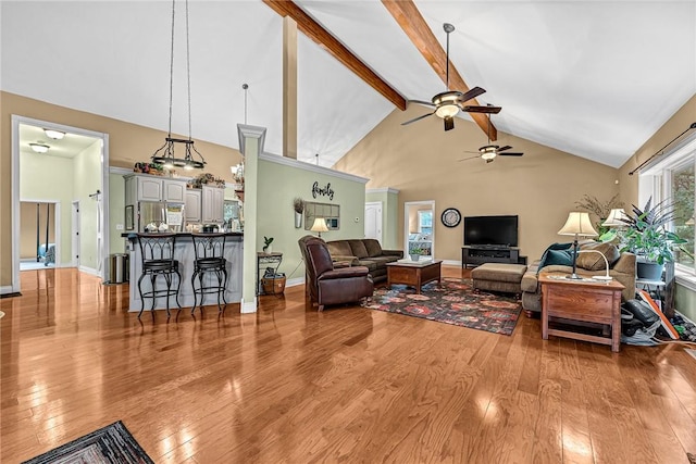 living room with beamed ceiling, ceiling fan, high vaulted ceiling, and light wood-type flooring