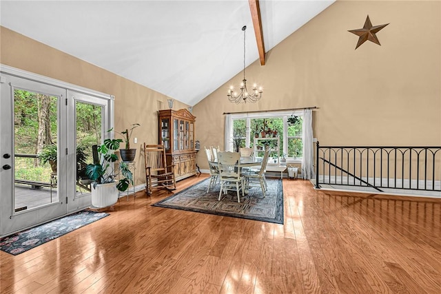 unfurnished dining area featuring beam ceiling, high vaulted ceiling, hardwood / wood-style floors, and a chandelier