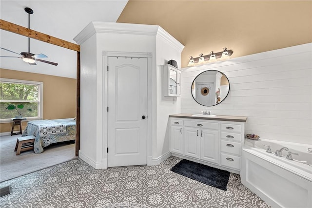 bathroom featuring a tub to relax in, vaulted ceiling with beams, vanity, ceiling fan, and tile patterned flooring