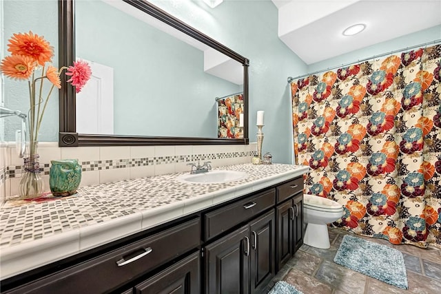 bathroom with tasteful backsplash, vanity, and toilet