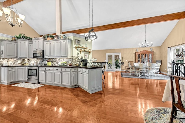 kitchen featuring hanging light fixtures, appliances with stainless steel finishes, gray cabinetry, and an inviting chandelier