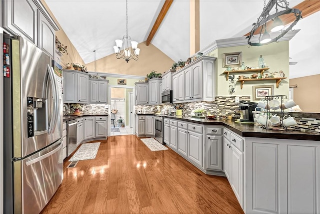 kitchen featuring gray cabinetry, decorative light fixtures, lofted ceiling with beams, light hardwood / wood-style flooring, and stainless steel appliances