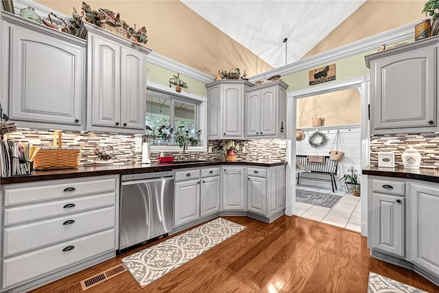 kitchen featuring lofted ceiling, sink, gray cabinets, and dishwasher