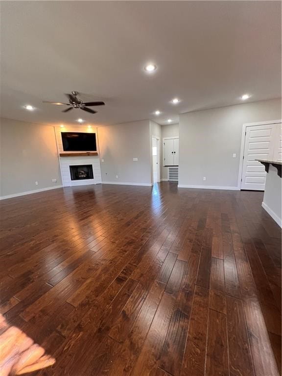 unfurnished living room featuring ceiling fan and dark hardwood / wood-style floors