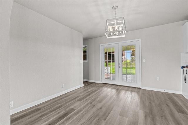 unfurnished dining area with wood-type flooring and french doors