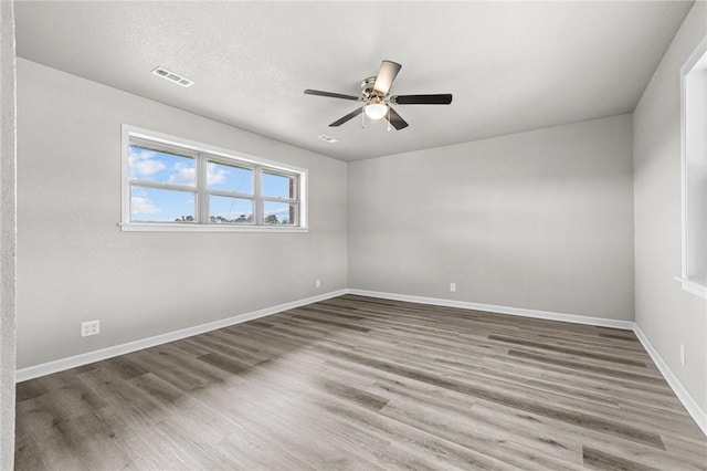 unfurnished room with ceiling fan, hardwood / wood-style floors, and a textured ceiling