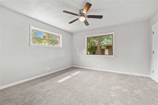 carpeted empty room with ceiling fan and a textured ceiling