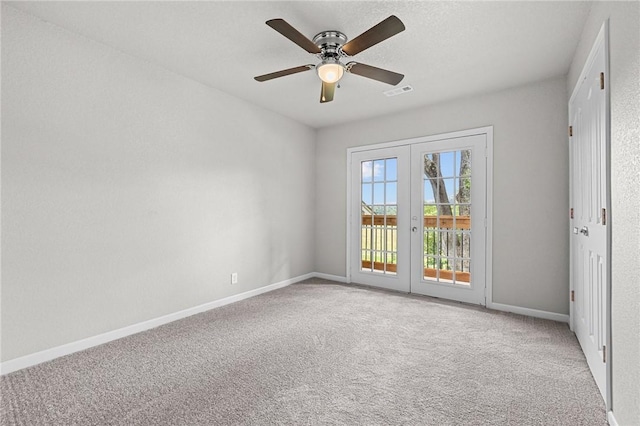 spare room with french doors, ceiling fan, and light carpet