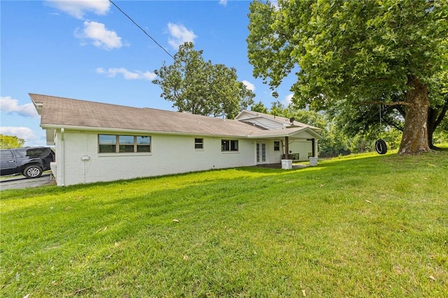 rear view of house featuring a yard