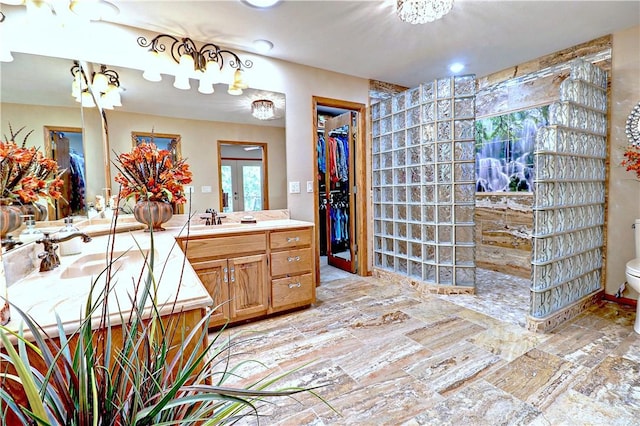 full bathroom with toilet, a spacious closet, french doors, and vanity