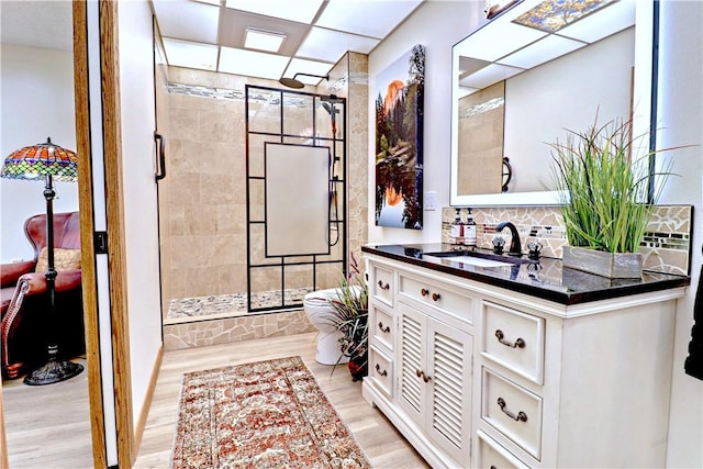 bathroom featuring walk in shower, wood finished floors, and vanity