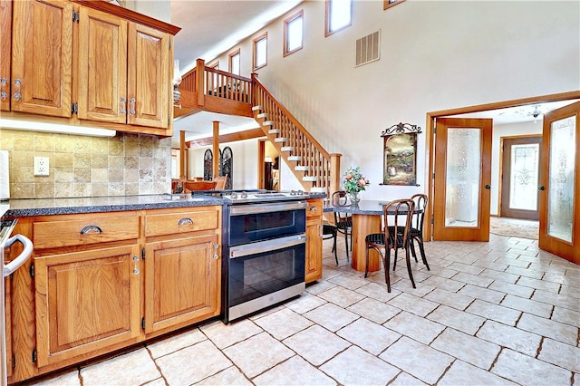 kitchen with visible vents, double oven range, french doors, brown cabinets, and tasteful backsplash