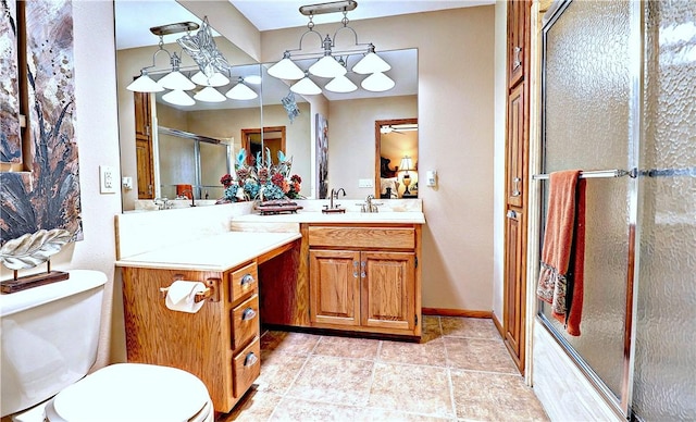 bathroom with toilet, a shower stall, vanity, tile patterned flooring, and baseboards