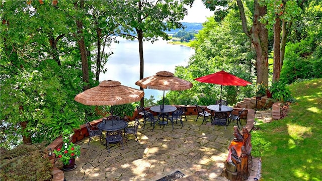 view of patio featuring a water view and outdoor dining area