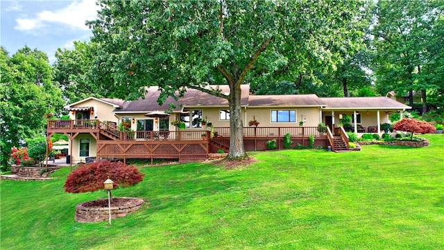 rear view of property featuring a deck, a yard, and stairway