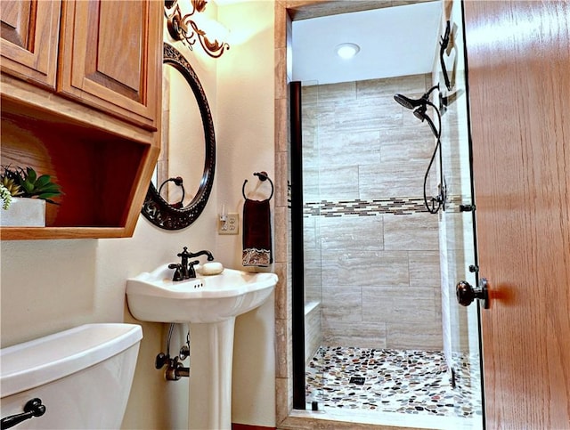 bathroom featuring toilet and a shower stall