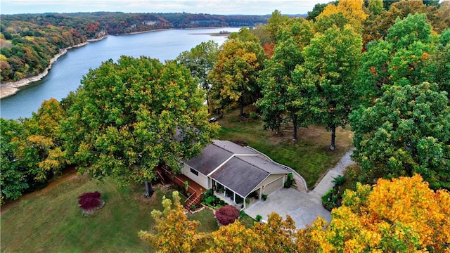 birds eye view of property featuring a water view and a wooded view