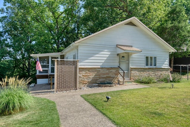 view of front of home with stone siding and a front yard