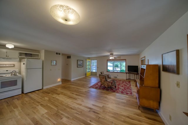 living area featuring baseboards, visible vents, and light wood-style floors