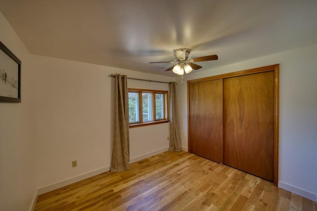 unfurnished bedroom with light wood-style floors, a closet, baseboards, and a ceiling fan