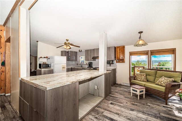 kitchen with backsplash, white refrigerator with ice dispenser, ceiling fan, and dark hardwood / wood-style floors