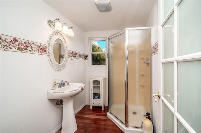 full bath with a stall shower, visible vents, and wood finished floors