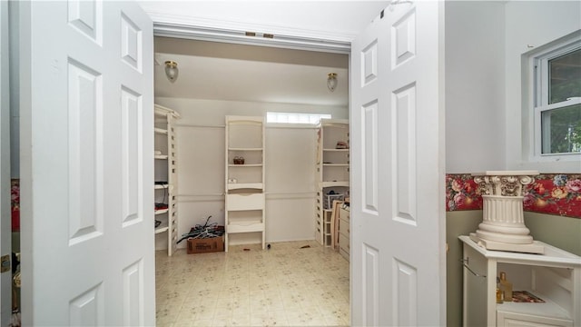 walk in closet with light floors