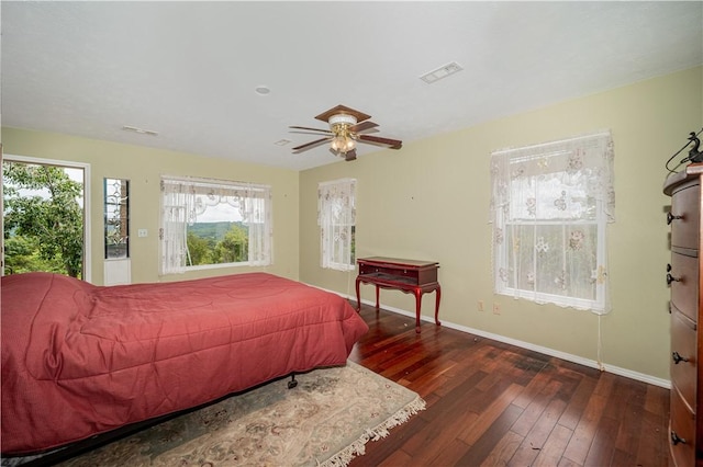 bedroom featuring visible vents, a ceiling fan, hardwood / wood-style flooring, and baseboards