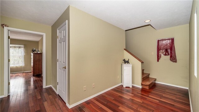 stairway with a textured ceiling and hardwood / wood-style flooring