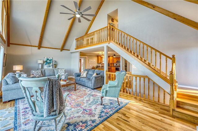 living room featuring ceiling fan, high vaulted ceiling, wood-type flooring, and beamed ceiling