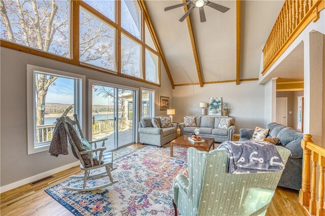 living room featuring a water view, high vaulted ceiling, plenty of natural light, and hardwood / wood-style floors