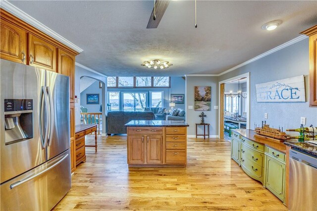 kitchen featuring appliances with stainless steel finishes, light hardwood / wood-style flooring, crown molding, and a textured ceiling