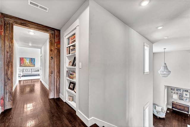 corridor with built in features, dark wood-style floors, baseboards, and recessed lighting