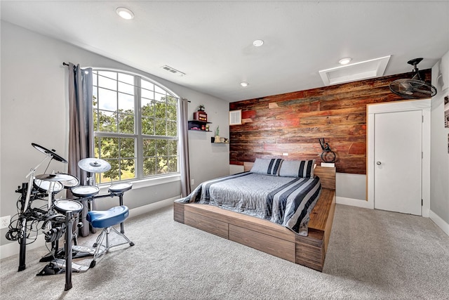 carpeted bedroom featuring wood walls