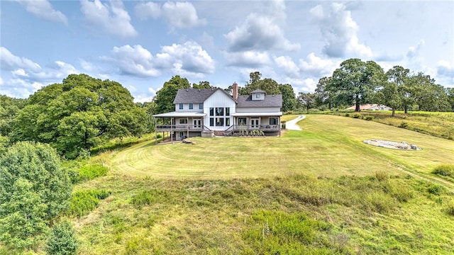 back of house featuring a lawn, a chimney, and a deck